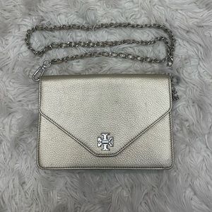 Tory burch cerametallic clutch with a long shoulder strap in light gold.